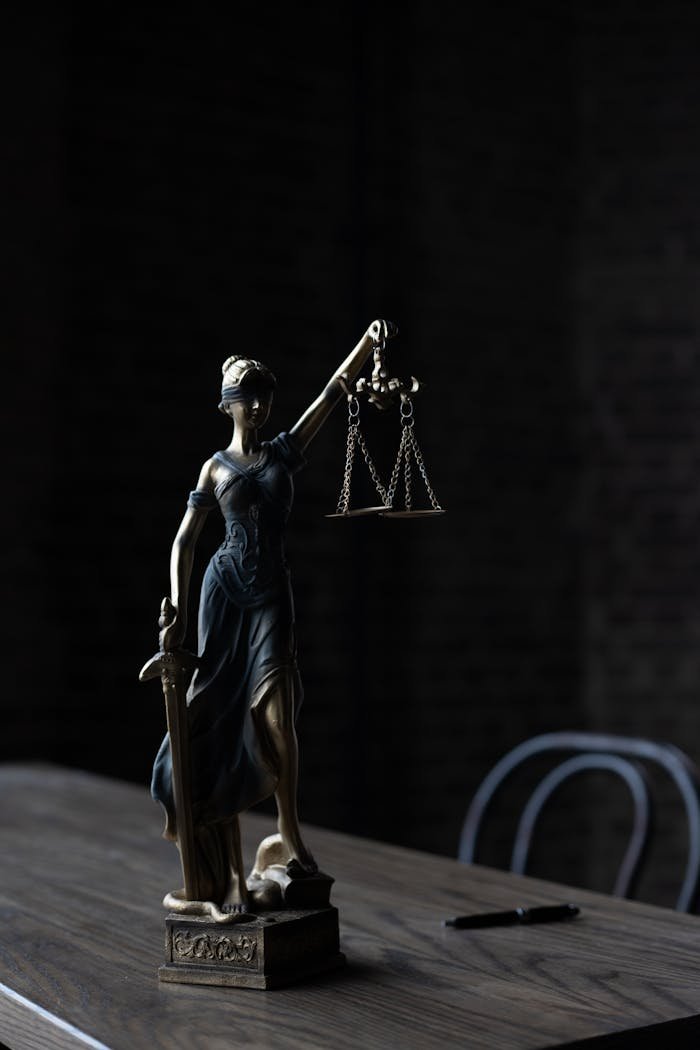 Ana Sayfa 2 Dramatic lighting on Lady Justice figurine, symbolizing law and fairness.